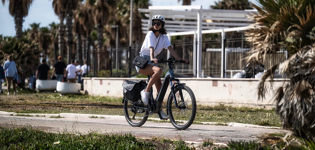 Donna con bici elettrica da trekking Brinke in ambiente urbano, perfetta per escursioni in bicicletta sia in città che fuori