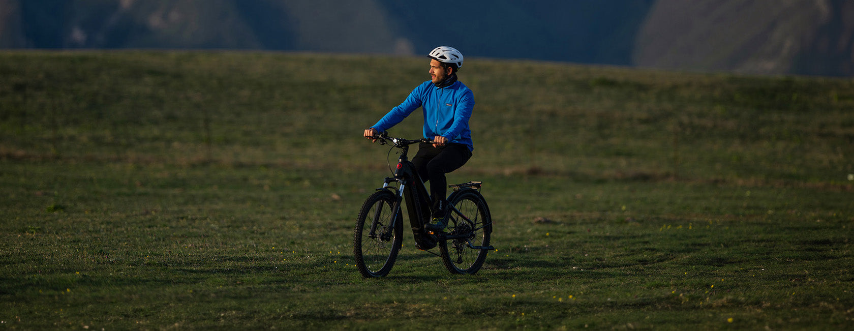 Uomo con bici elettrica da mtb Brinke in ambiente montano, perfetta per escursioni in bicicletta