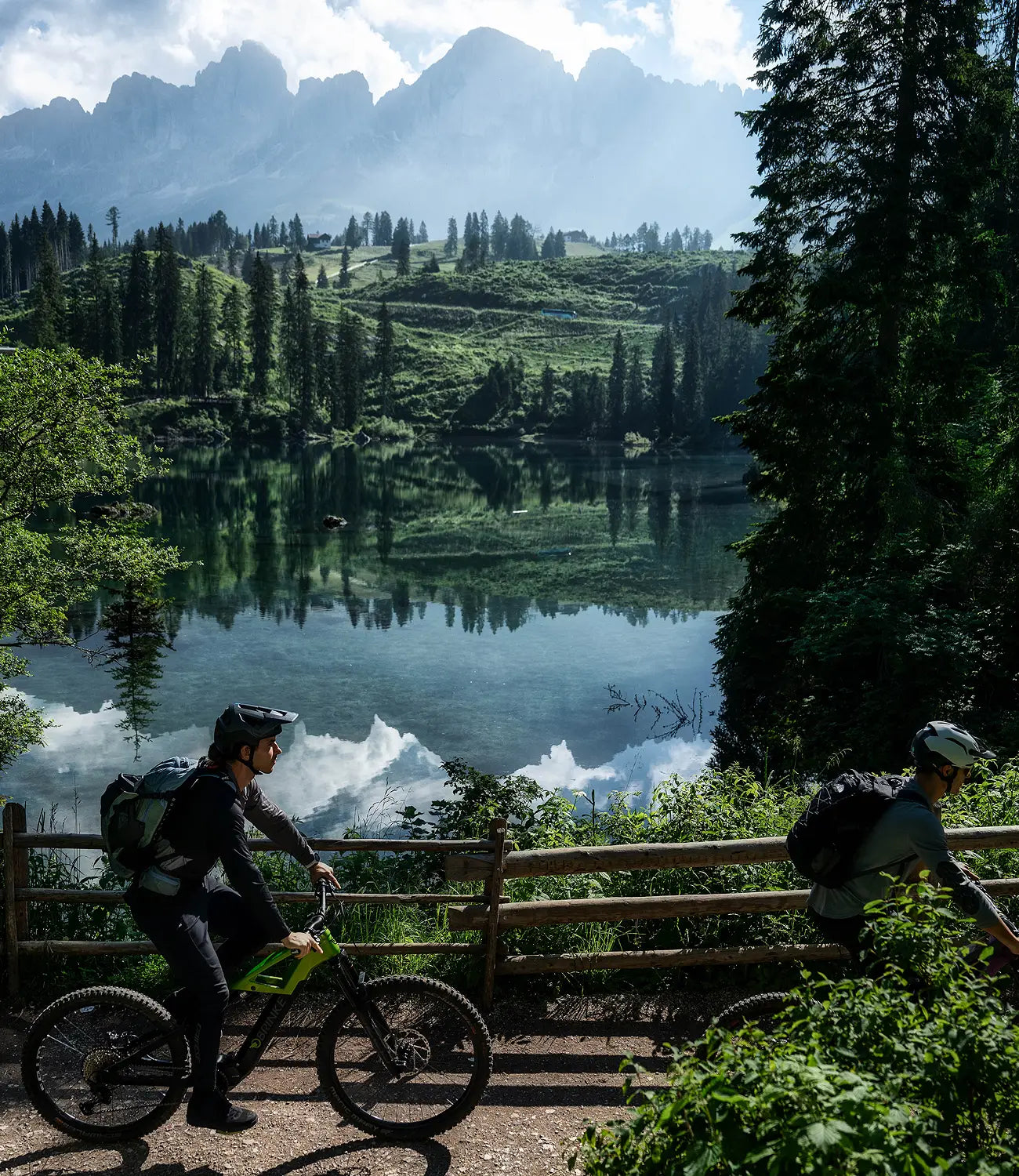 Ciclisti con emtb Brinke a bordo lago montano durante un travel experience in e-mtb