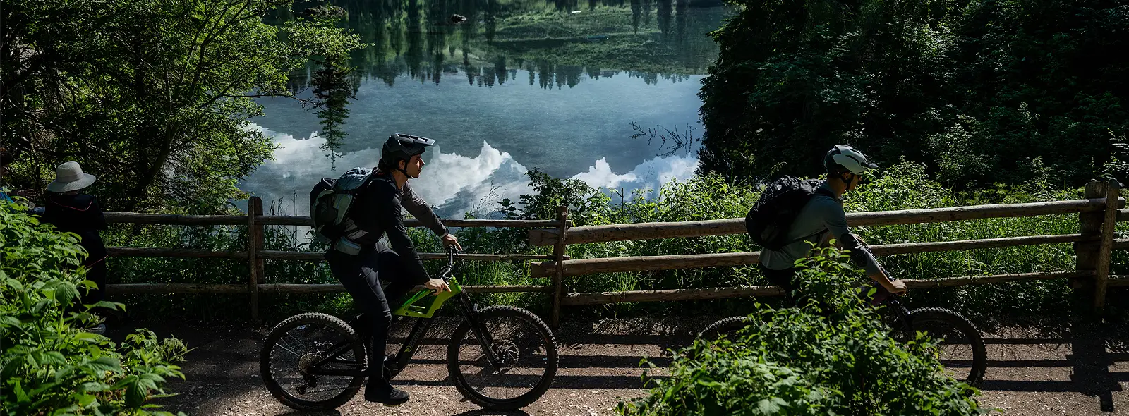 Ciclisti con emtb Brinke a bordo lago montano durante un travel experience in e-mtb